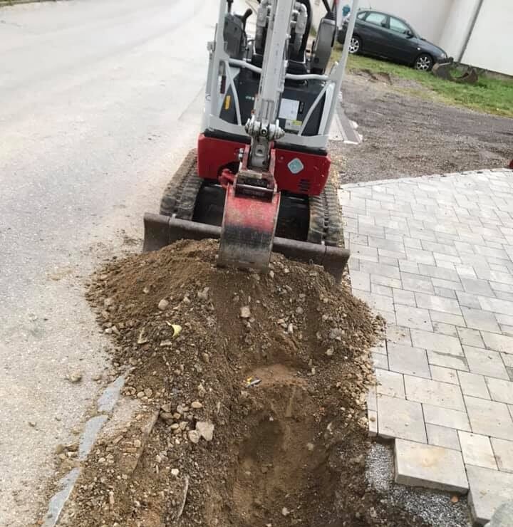 Bagger hebt Anschluss für Glasfaserkabel aus.